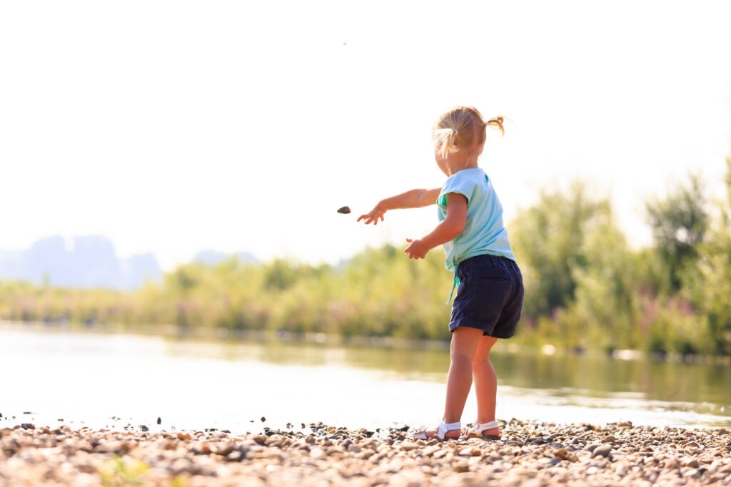 Kind gooit steentje in het water ©Kobe Van Looveren