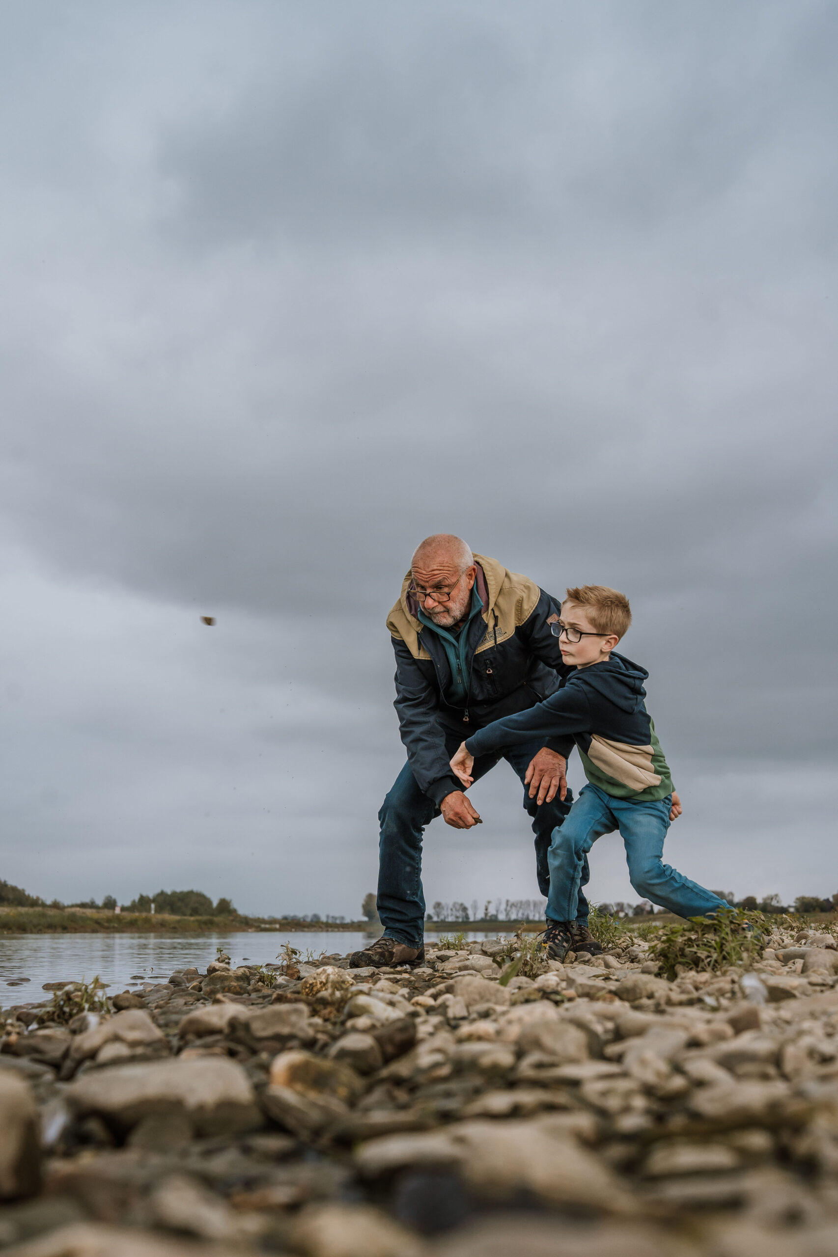Man en kind gooien steentjes in het water ©Bjorn Snelders